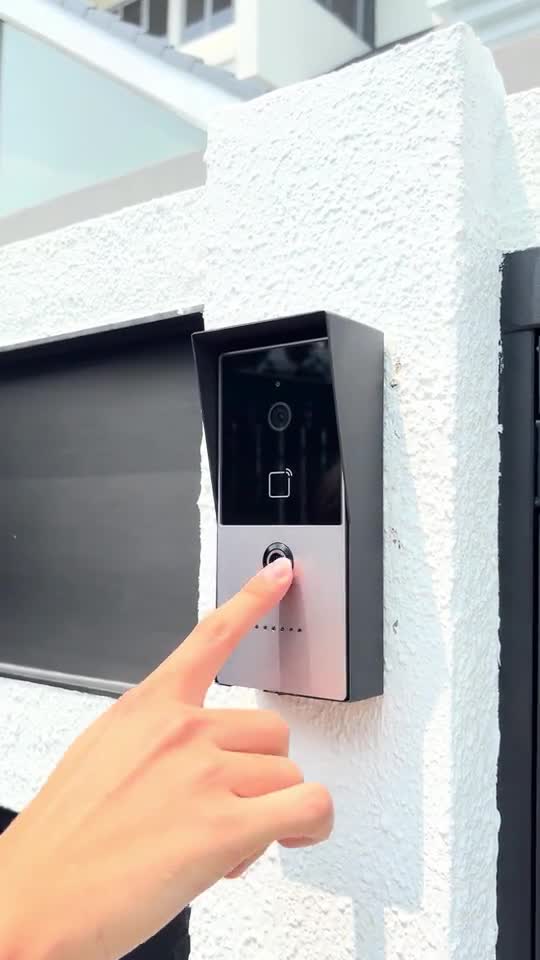 A visitor pressing the doorbell beside the entrance gate