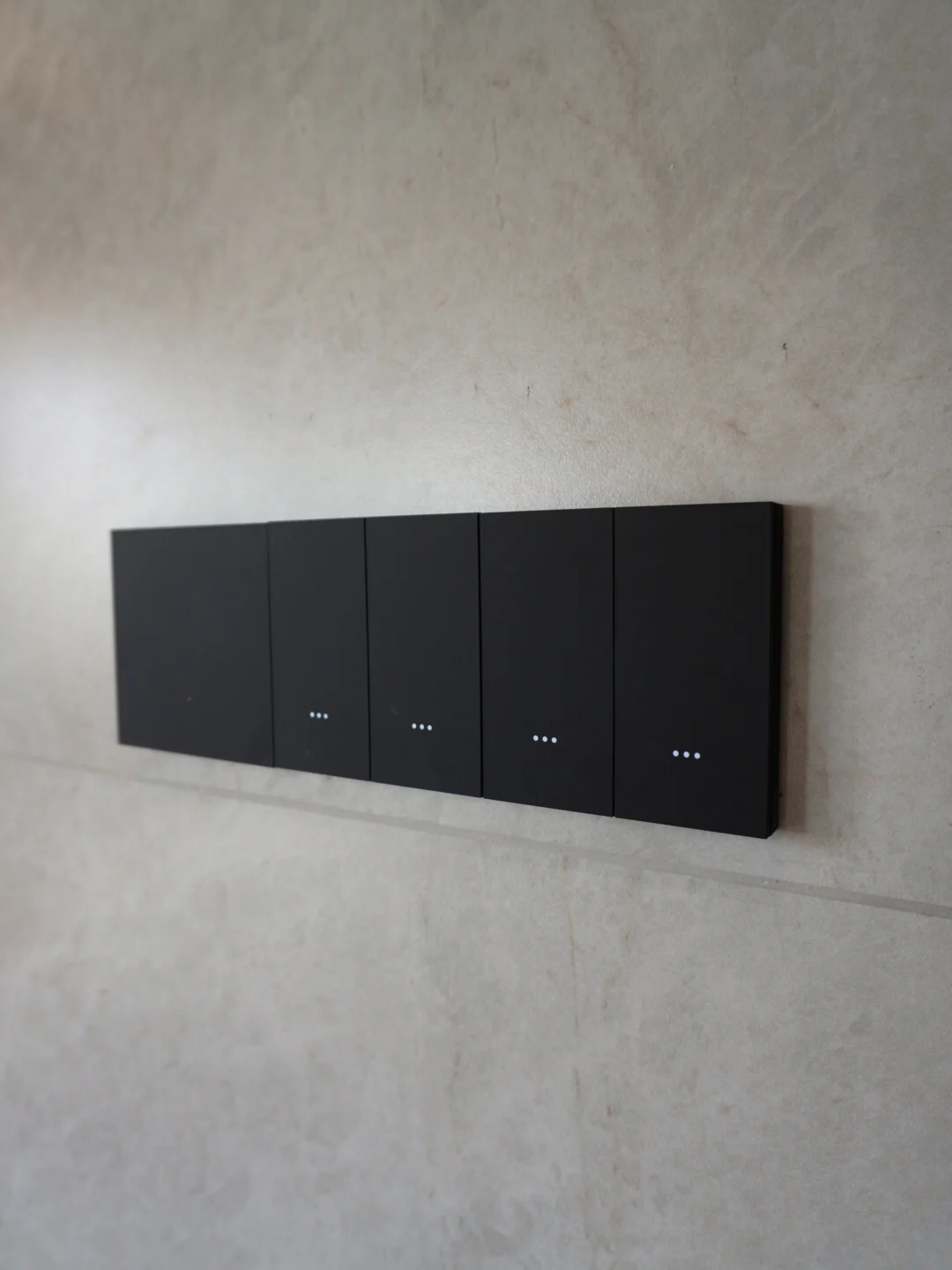 Black smart switch aligned on a textured wall