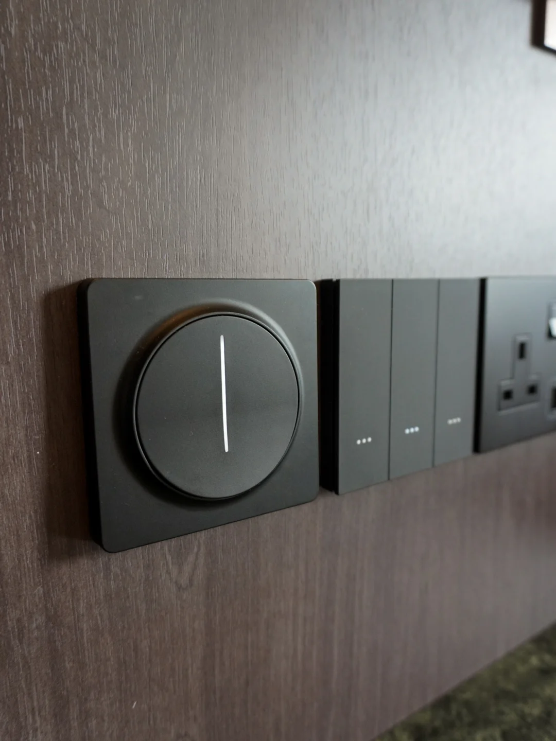 Dark switches and a circular wall control on a textured wall