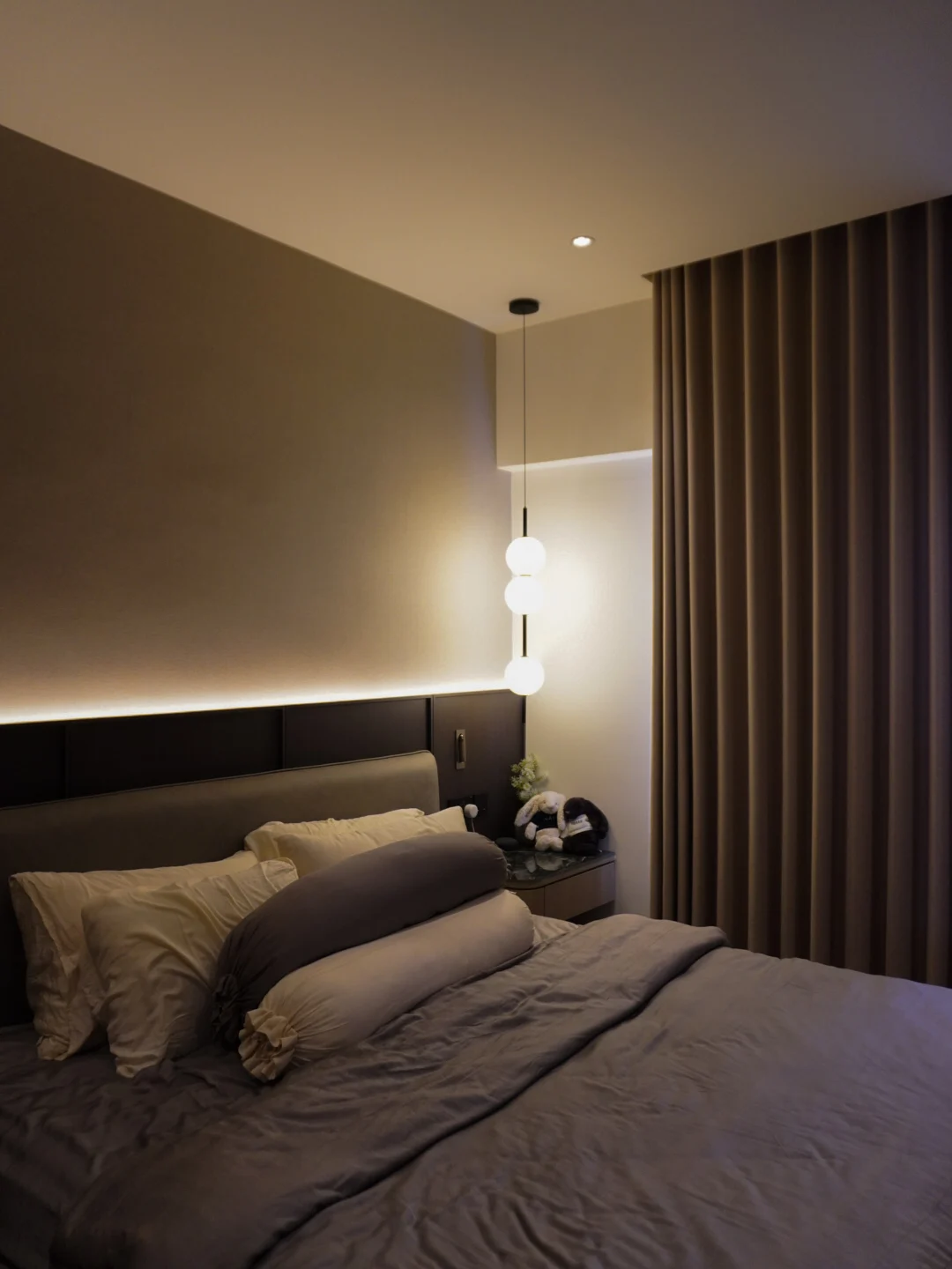 Bedroom in a completed NexHome project, with soft lighting and full-height curtains